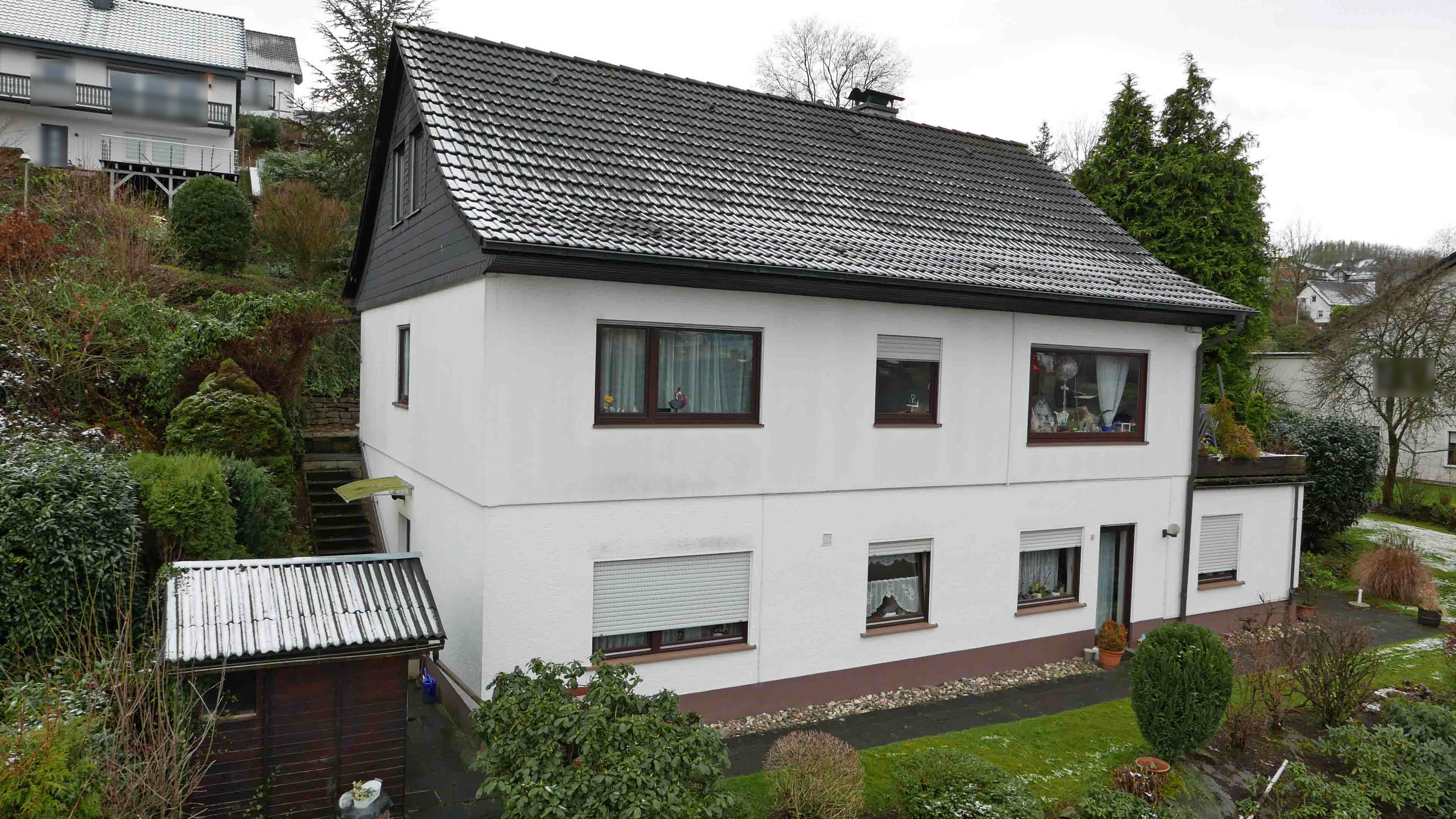 Gummersbach-Bernberg: Wohnhaus mit 2-3 Wohnungen, Hausrückseite. Links: Eingang zur Wohnung im Untergeschoss