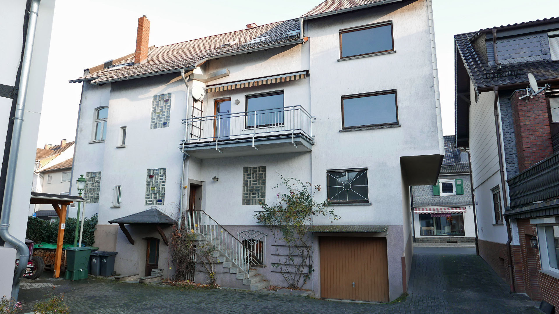 Morsbach/Zentrum: Wohn-/Geschäftshaus mit 2 Wohnungen und Ladenlokal, Hausrückseite / Hinterhof mit Zufahrt (rechts)