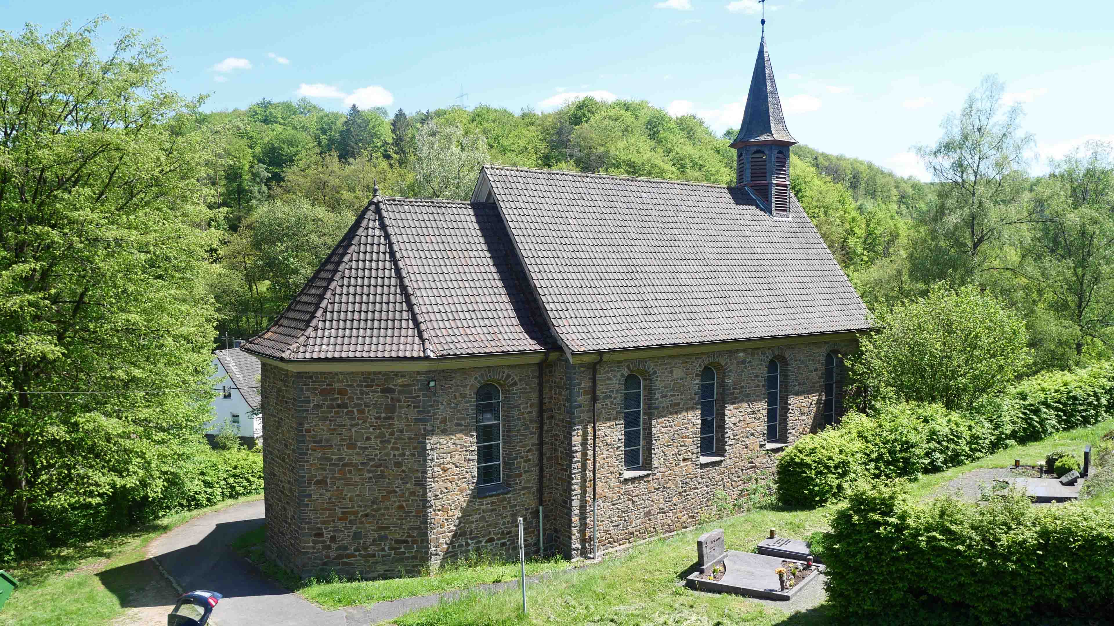 Morsbach-Ellingen: Stilvolle, kleine Bruchsteinkirche, Rückseite mit kleinem, stillgelegtem Friedhof