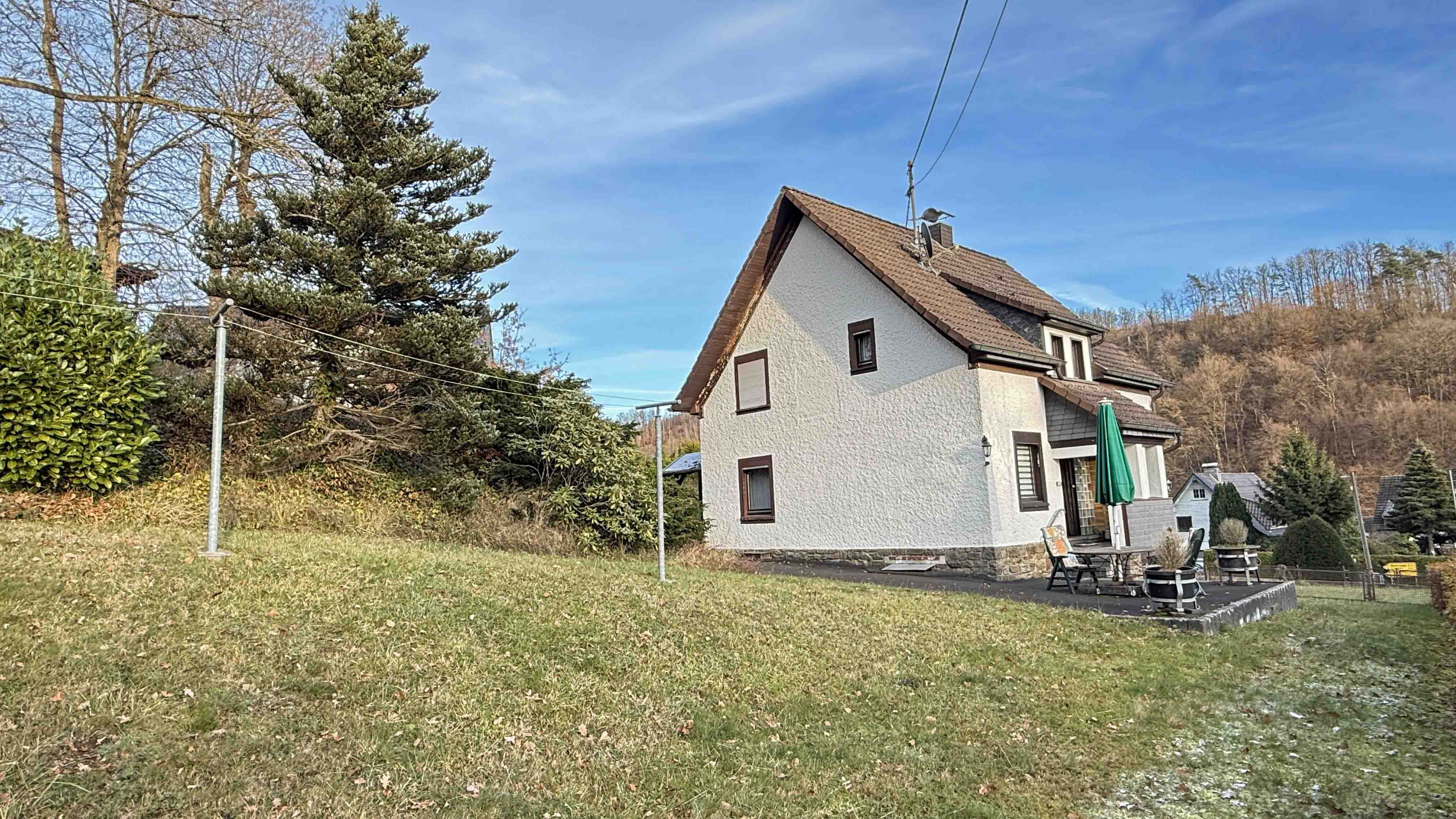 Morsbach: Baujahr 1939, aber modernisiert, barrierefrei, preiswert und gut, Rückseite mit Rasen und hauseigenem Wald